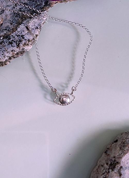 Sterling silver eye pendant with a pupil in the shape of an apple core